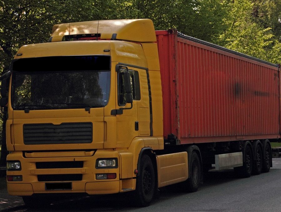 A haulage truck pulling a container trailer on the road
